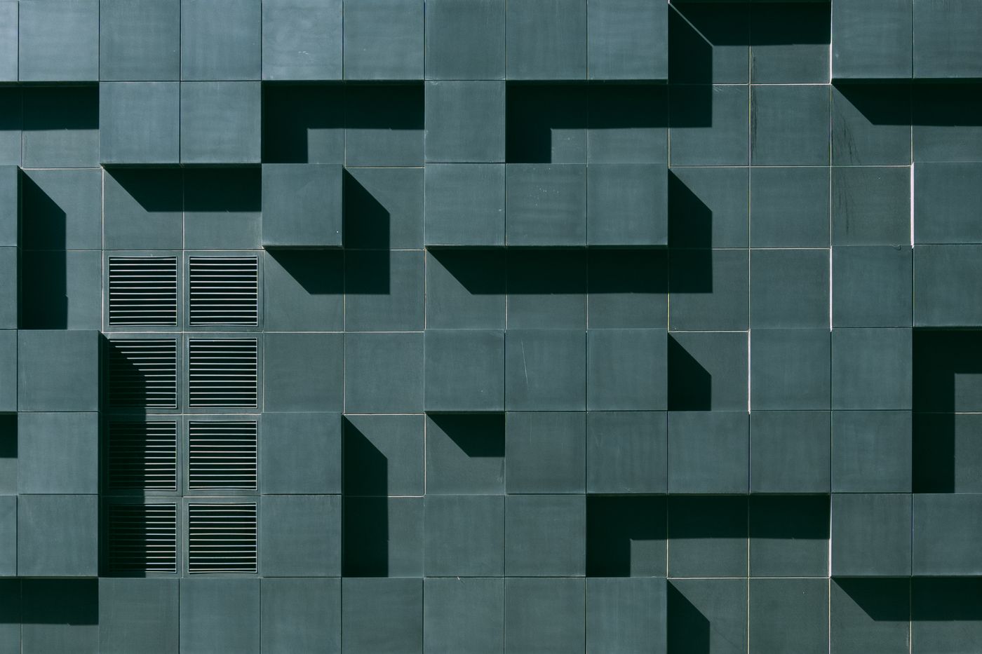 Concrete building with a geometric green facade