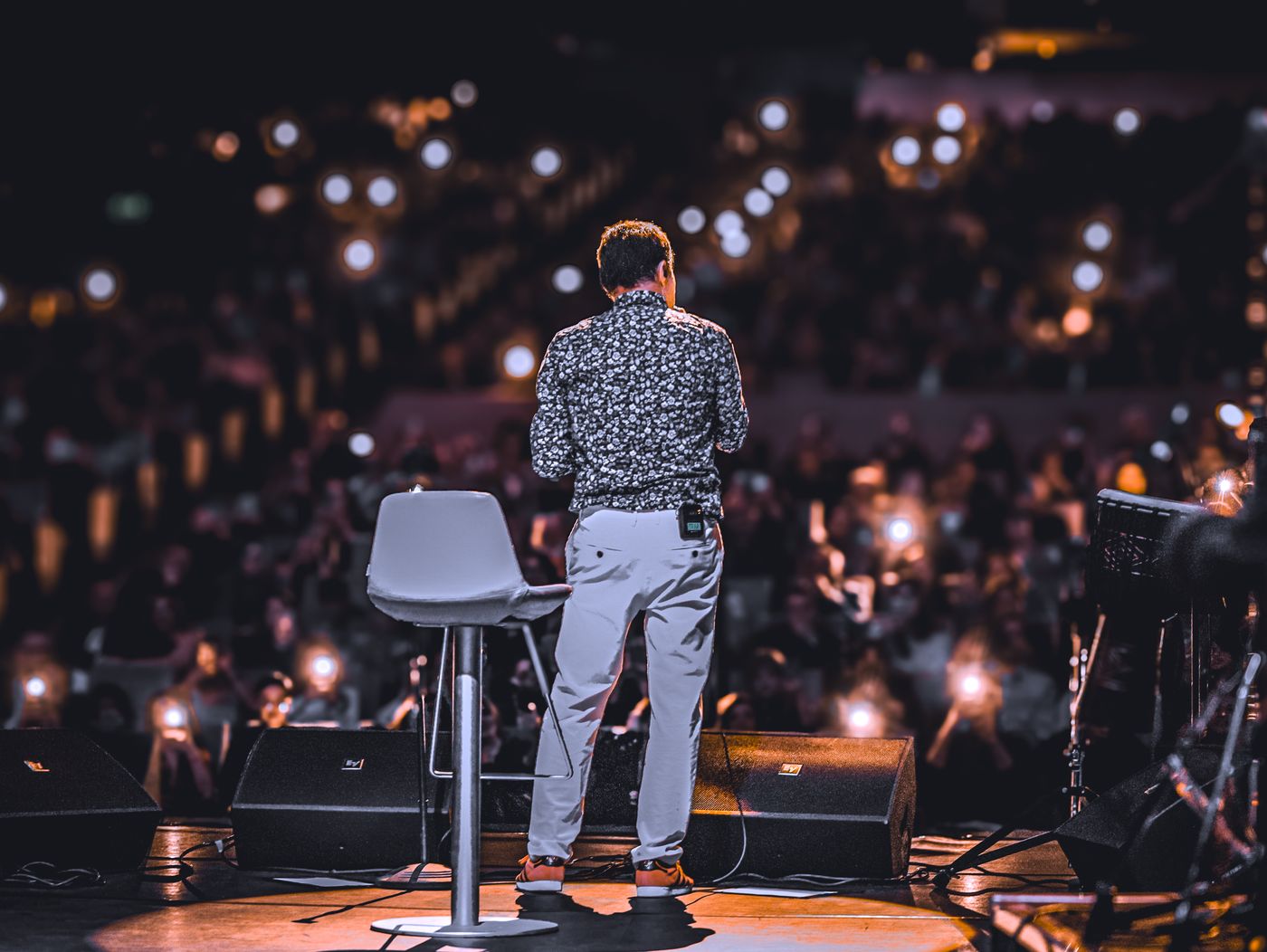A speaker on stage under audience lights